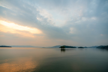 Obraz premium beautiful blue sky green forest mountains lake view at Kaeng Krachan National Park, Thailand. an idea for backpacker hiking on long weekend or a couple, family holiday activity camping relaxing