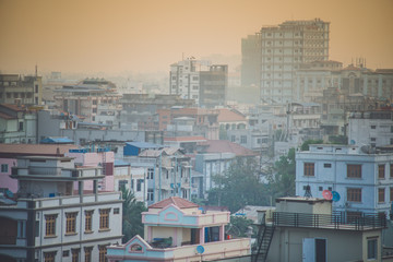 Dusty sunrise in Mandalay Myanmar downtown city skyline.