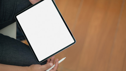 Close-up view of man using blank screen digital tablet while sitting in his office room