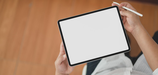 Cropped shot of view of man using blank screen digital tablet while sitting in his office room