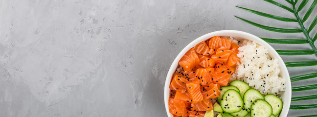 Hawaiian salmon bowl with cucumbers, avocado, sesame seeds and rice. Top view, overhead, flat lay, mock up, template. Healthy food concept