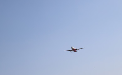 Fototapeta na wymiar Scenery of airplane flying in smog blue sky.