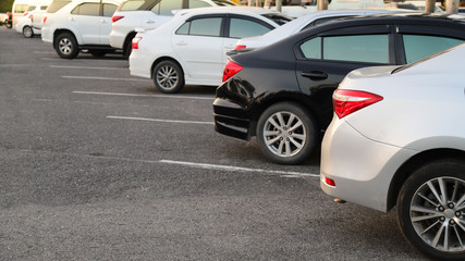 Fototapeta premium Closeup of rear, back side of bronze car with other cars parking in outdoor parking area