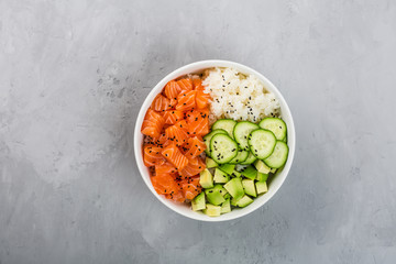 Hawaiian salmon bowl with cucumbers, avocado, sesame seeds and rice. Top view, overhead, flat lay, mock up, template. Healthy food concept