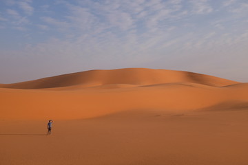 Fototapeta na wymiar A man in front of giant sand dunes in the desert near Riyadh, Saudi Arabia