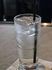 Glass of cold water with ice cubes and straw