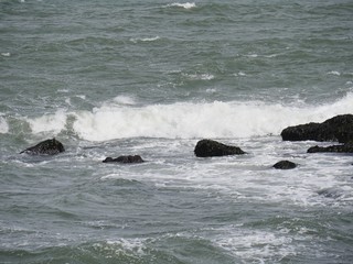 Waves break against rocks in a coastal area in New England