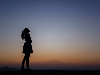 Fototapeta premium silhouette of young woman freedom feeling at sunset,thinking