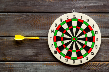 Goal achievement concept. Dartboard and arrows or dart on dark wooden background top view copy space
