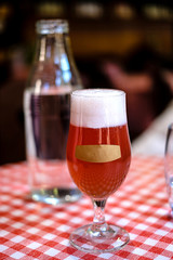 Refreshing glass of red ale beer with empty label on front of glass.