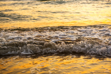 The sea with waves hit the sandy beach in the morning, with copy space text