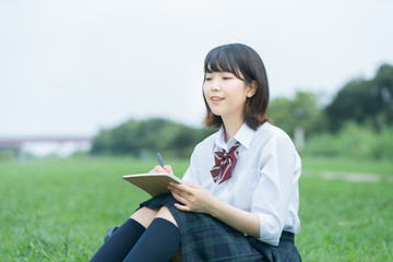 屋外で勉強する女子高生