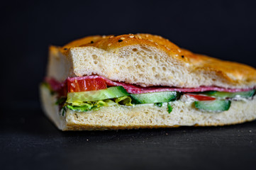 Flatbread sandwich with salami tomato cucumber salad and gravy