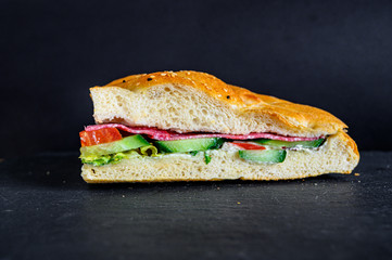 Flatbread sandwich with salami tomato cucumber salad and gravy