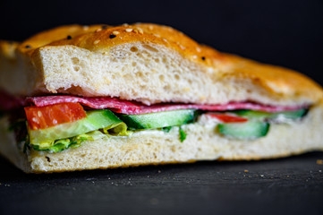 Flatbread sandwich with salami tomato cucumber salad and gravy