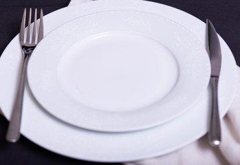 white plate with appliances served on the table with a black tablecloth