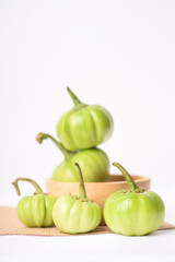 Close up of organic raw green tomato on a white background