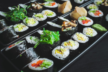 Two vegetarian sushi platter with maki, futomaki and seaweed gunkans in the middle.