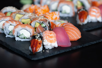 Sushi set with nigiri sushi, uramaki California, Philadelphia, Unagi rolls on stone plate.
