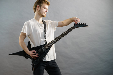 Man adjusting electric guitar