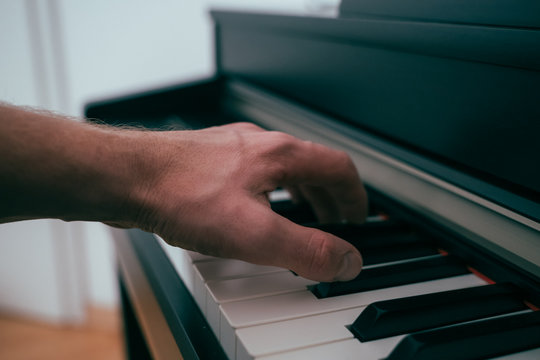 Eine Hand spielt auf dem Klavier einen Akkord (Moody)