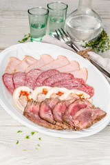Assorted meat snacks on a white plate
