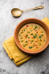 Vegetable masala oats khichadi served in a bowl. selective focus