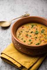 Vegetable masala oats khichadi served in a bowl. selective focus