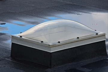A dirty skylight window on a wet roof after rain shower