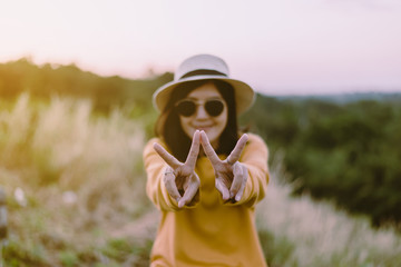 Hipster young asian woman showing two fingers at nature,Happy and smiling,Positive thinking