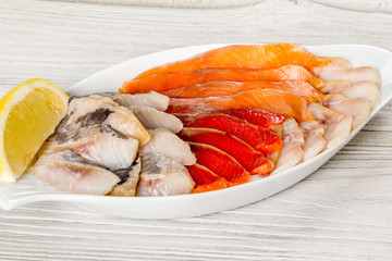 Assorted fish on a white plate with lemon