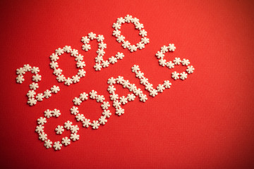 2020 Goals. Creative inscription "2020 Goals" written in white snowflakes on a red background for design. New Year 2020 concept