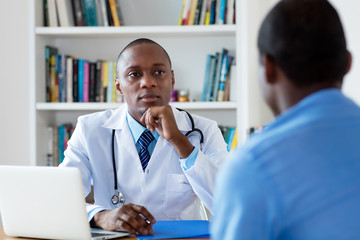 African american doctor listening to problems of male patient