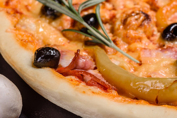 Tasty fresh hot pizza against a dark background. Pizza, food, vegetable, mushrooms.  It can be used as a background