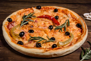 Tasty fresh hot pizza against a dark background. Pizza, food, vegetable, mushrooms.  It can be used as a background
