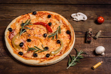 Tasty fresh hot pizza against a dark background. Pizza, food, vegetable, mushrooms.  It can be used as a background