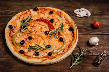 Tasty fresh hot pizza against a dark background. Pizza, food, vegetable, mushrooms.  It can be used as a background