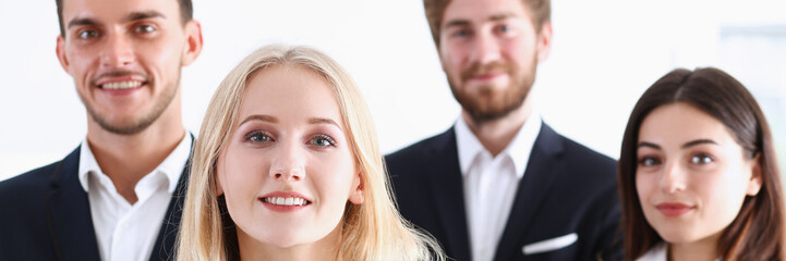 Group of smiling people stand in office