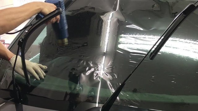installs a tint film for the car glass