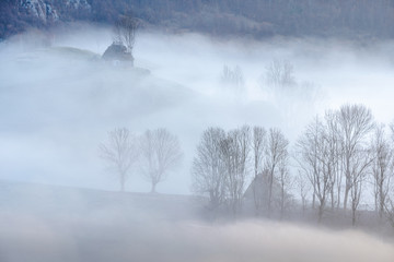 Alpine sea in the mountains. Dumesti a village from Romania cover in fog.