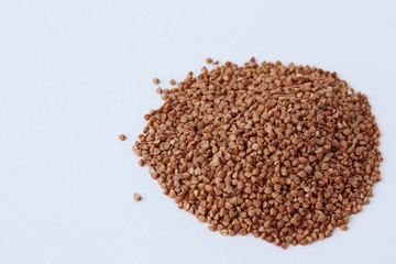 hill of raw brown buckwheat on a light background