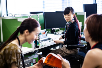 雑誌を一緒に読む女性社員達