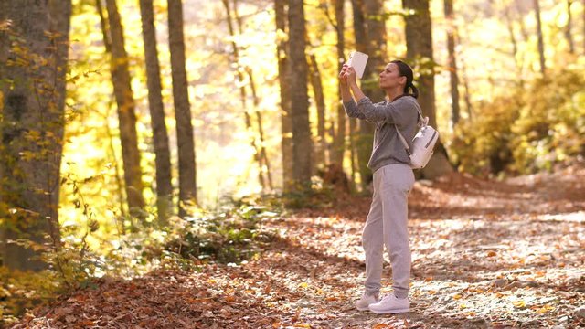 Woman capturing beautiful autumn park