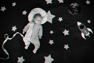 baby boy is asleep and dreams himself an astronaut in space