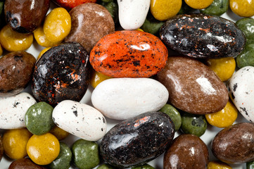 Pebble-dragee with apricots, chocolate, mandarin and marzipan. Tasty, bright, shot on a white background.