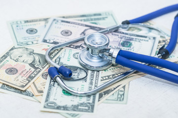 The blue stethoscope sits on the jumbled dollar