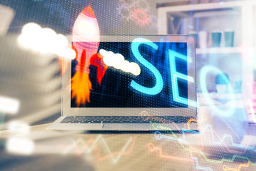 Multi exposure of table with computer and seo drawing hologram. Search optimization concept.
