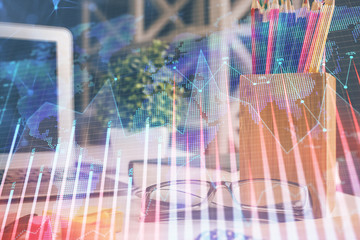 Financial chart hologram with glasses on the table background. Concept of business. Double exposure.
