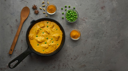 Cooking tasty chicken curry in pan with spices. Flat lay, top view with copy space