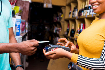contactless payment with a credit card and a mobile point of sale system in a local african retail...